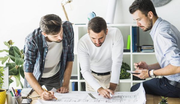 group-male-architect-analyzing-blueprint